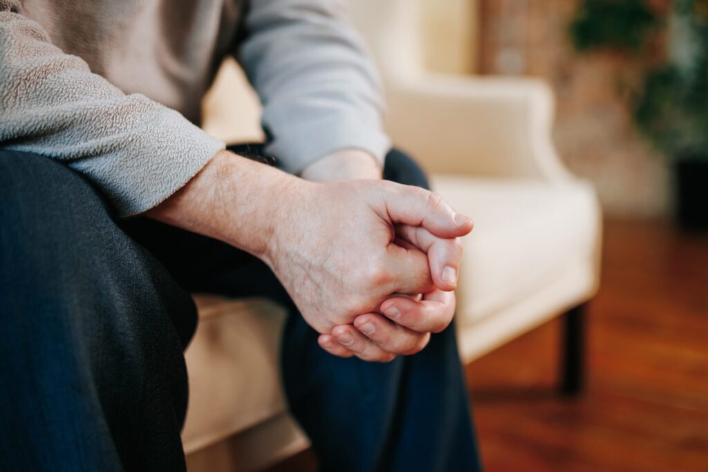 the hands of a senior man close up, he is at the psychiatrist